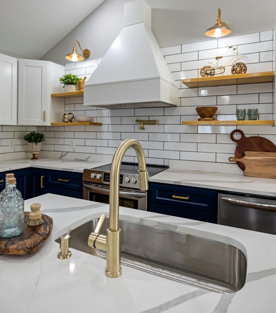 Stylish kitchen featuring marble countertops, brass fixtures, and open shelving.