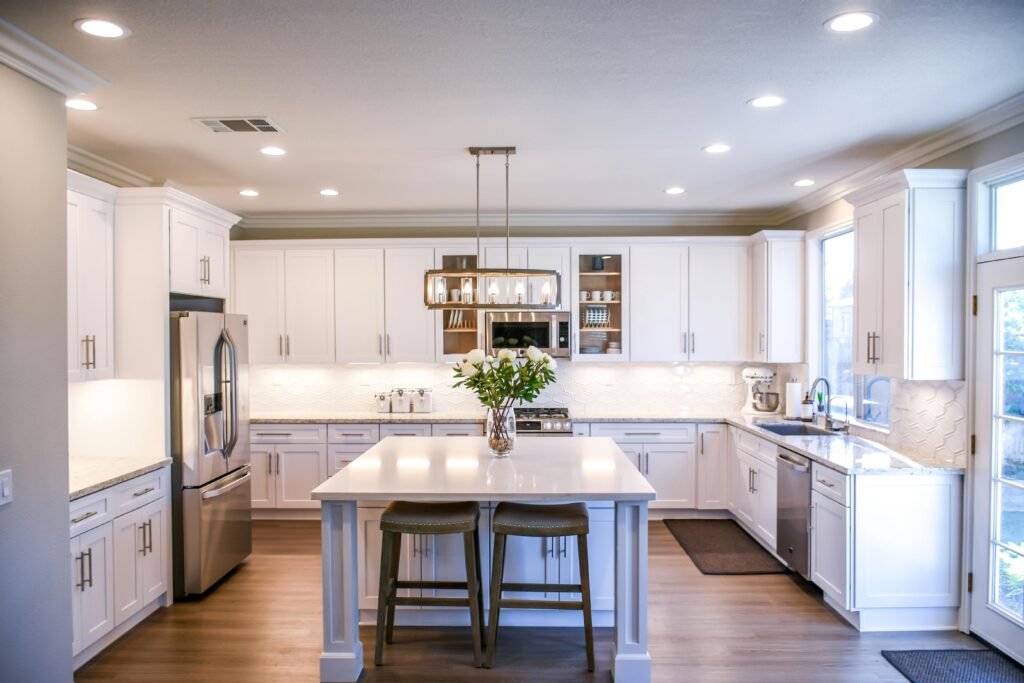 Spacious and elegant kitchen featuring white cabinetry, island, and stainless steel appliances, and Custom countertops